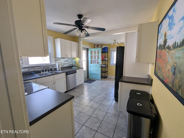 kitchen featuring a sink, white cabinets, freestanding refrigerator, and dishwasher