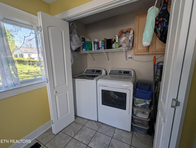 laundry room featuring light tile patterned floors, separate washer and dryer, laundry area, and baseboards