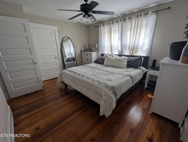 bedroom with dark wood-style floors and ceiling fan