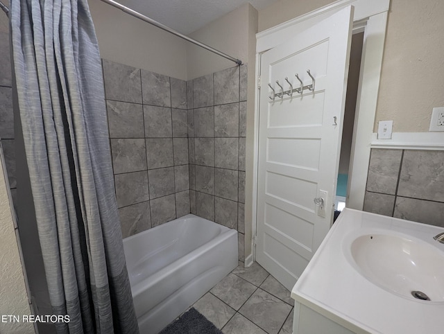 full bathroom with a sink, tile walls, and shower / bath combo with shower curtain