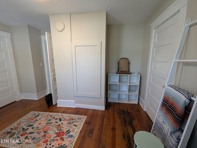 bedroom featuring dark wood-type flooring and baseboards
