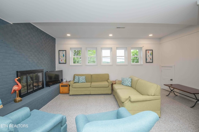 living area with recessed lighting, a brick fireplace, speckled floor, and visible vents