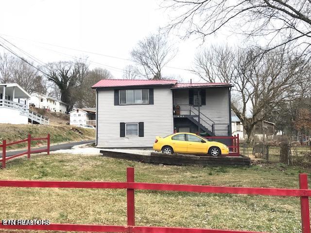 view of front of property featuring a front yard, stairs, and fence