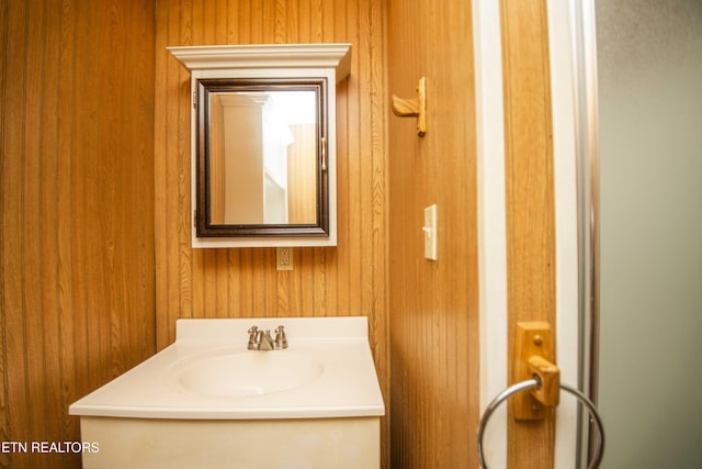 bathroom featuring wood walls and vanity