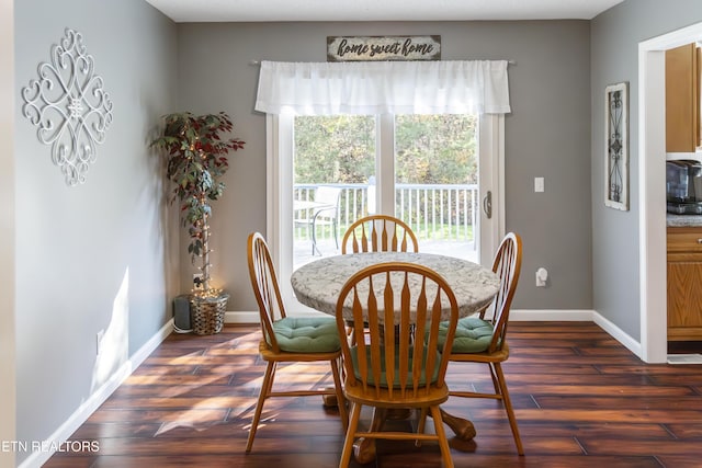 dining area with baseboards and dark wood-type flooring