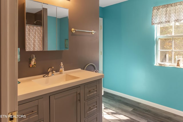 full bath featuring baseboards, vanity, and wood finished floors