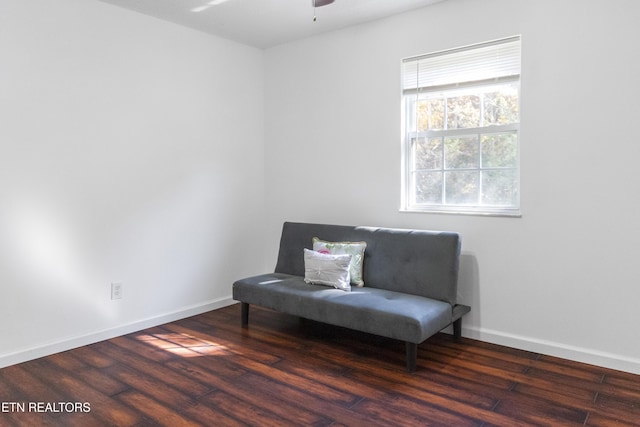 living area with baseboards, a ceiling fan, and wood finished floors