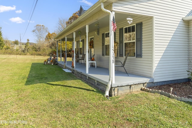 view of side of home with a yard and covered porch