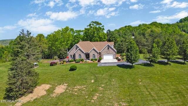 300 Lowe Rd, Huntsville, TN 37756 - view of front facade featuring an attached garage, a view of trees, aphalt driveway, and a front yard