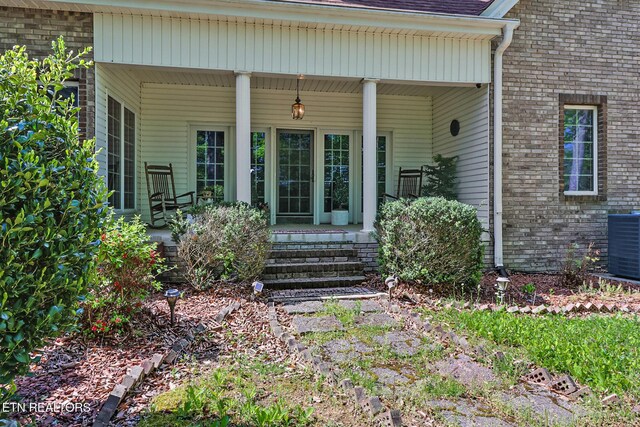 300 Lowe Rd, Huntsville, TN 37756 - view of exterior entry with covered porch, brick siding, and central AC