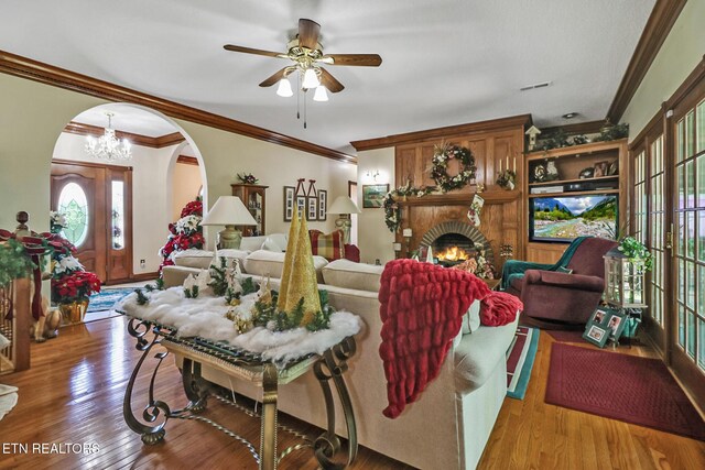 300 Lowe Rd, Huntsville, TN 37756 - living room with a fireplace, arched walkways, ceiling fan with notable chandelier, wood finished floors, and ornamental molding