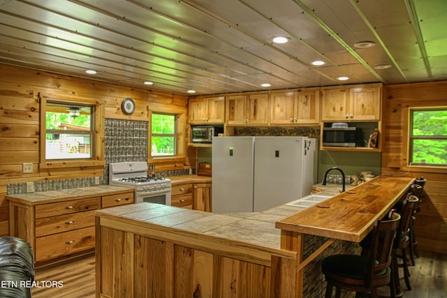 2025 Allardt Tinch Rd, Jamestown, TN 38556 - kitchen with white appliances, wood finished floors, a sink, plenty of natural light, and wood walls