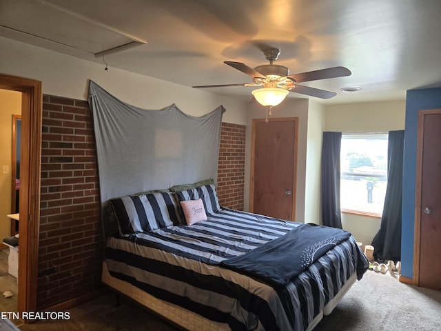 carpeted bedroom with brick wall, attic access, a ceiling fan, and visible vents