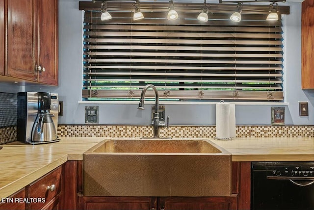 interior details with tasteful backsplash, a sink, and black dishwasher