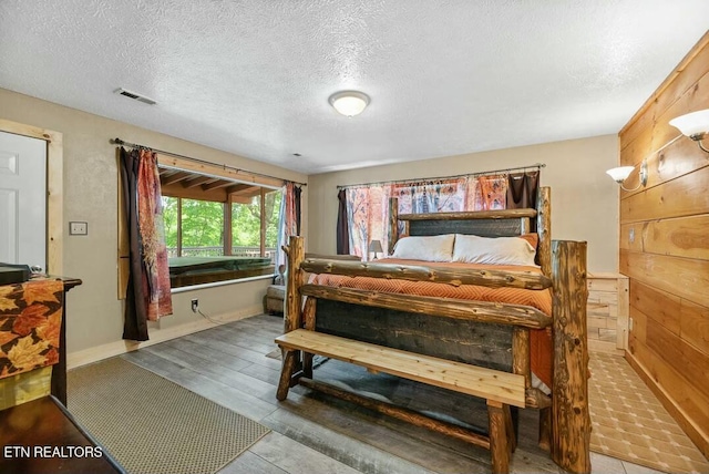bedroom with a textured ceiling, baseboards, and visible vents