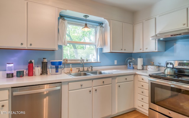 kitchen with light countertops, white cabinetry, stainless steel appliances, and a sink