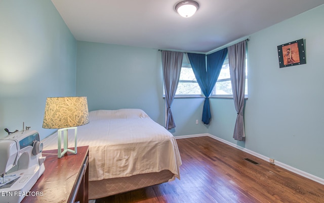 bedroom featuring visible vents, baseboards, and dark wood finished floors