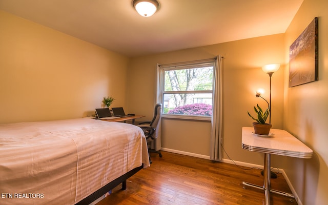 bedroom featuring baseboards and wood finished floors