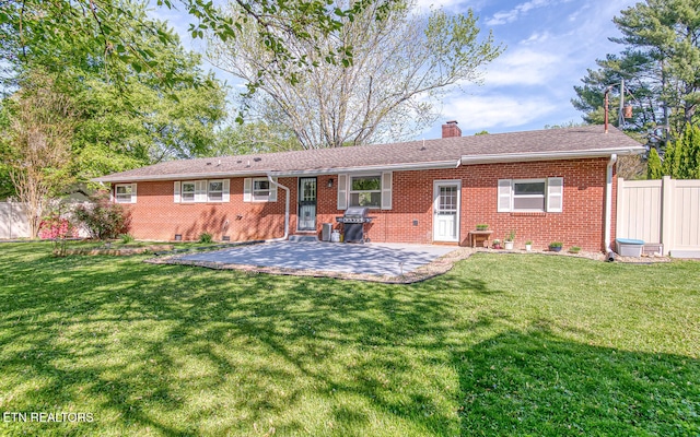 rear view of house featuring fence, a patio area, a chimney, and brick siding