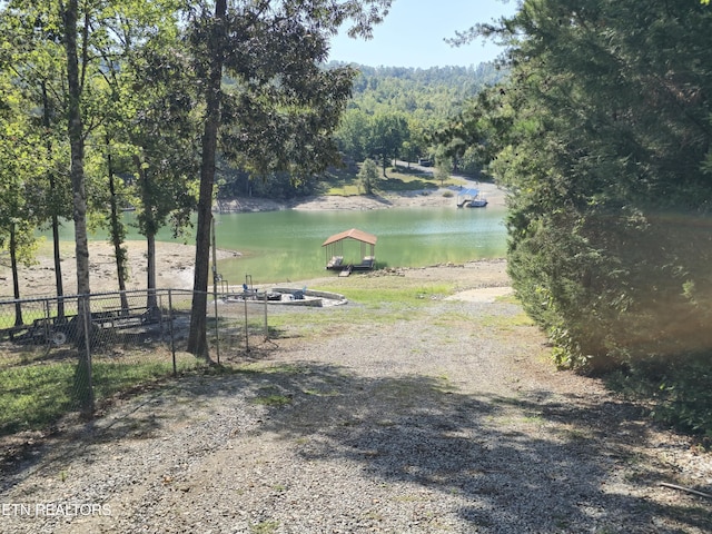 view of home's community featuring fence and a water view
