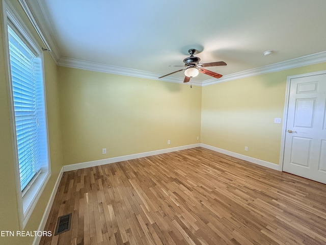 empty room with visible vents, light wood-style floors, ceiling fan, and crown molding