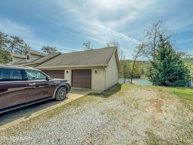 view of property exterior featuring a garage, driveway, and a shingled roof