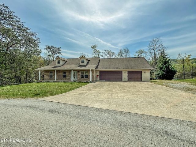 view of front facade with a garage, driveway, a front lawn, and covered porch