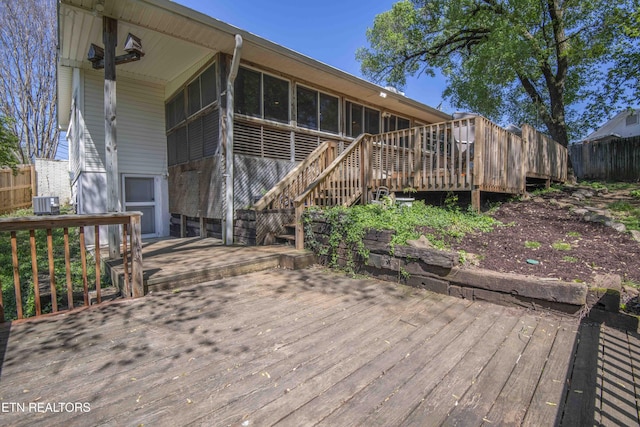 wooden deck featuring a sunroom, cooling unit, fence, and stairway
