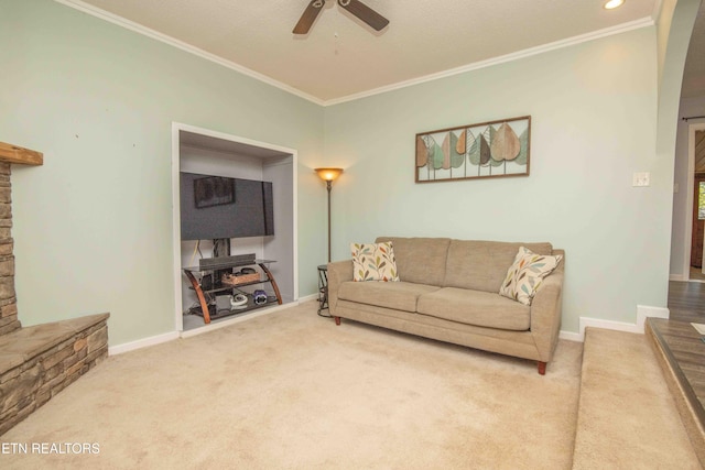 living area featuring carpet flooring, ceiling fan, baseboards, and ornamental molding