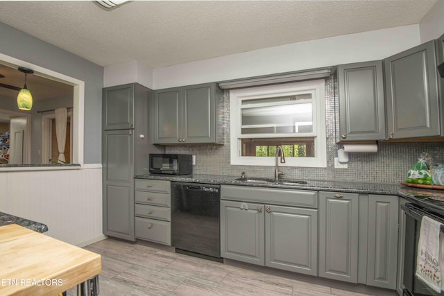 kitchen featuring tasteful backsplash, a sink, black appliances, and gray cabinets