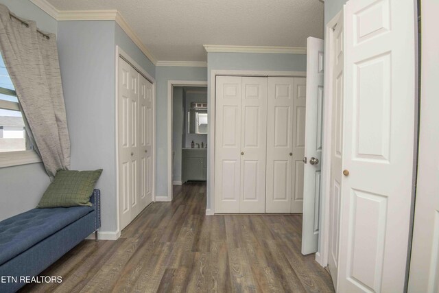 living area with crown molding, baseboards, wood finished floors, and a textured ceiling