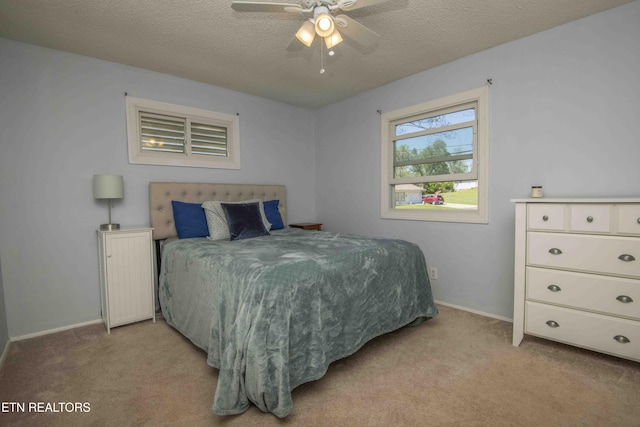 bedroom with light colored carpet, baseboards, a ceiling fan, and a textured ceiling