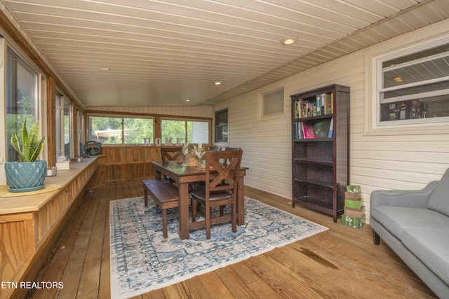 sunroom with wood walls, a wooden deck, hardwood / wood-style floors, and wood ceiling