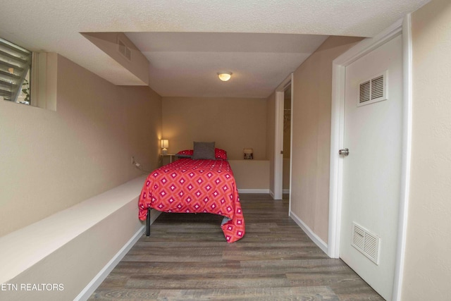 bedroom featuring visible vents, baseboards, and wood finished floors