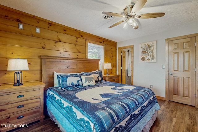 3219 Grouse Ridge Ln, Sevierville, TN 37862 - bedroom featuring wood finished floors, a textured ceiling, wood walls, and ceiling fan