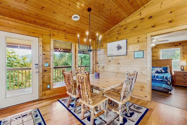 3219 Grouse Ridge Ln, Sevierville, TN 37862 - dining area featuring vaulted ceiling, healthy amount of natural light, a chandelier, wood walls, and wood finished floors