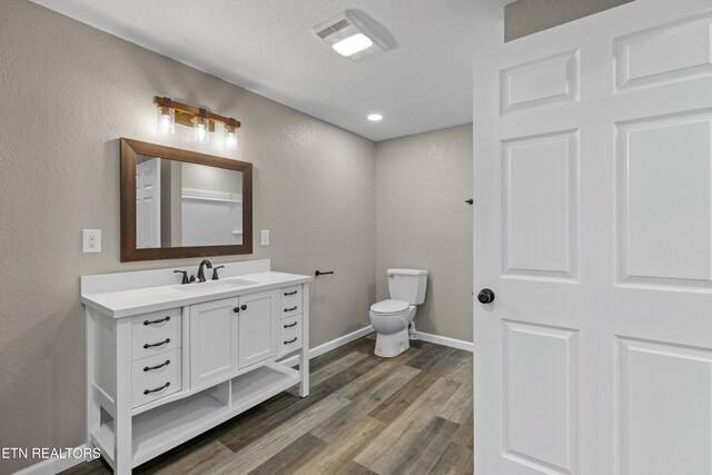 613 N St, Newport, TN 37821 - bathroom with wood finished floors, toilet, vanity, and a textured wall