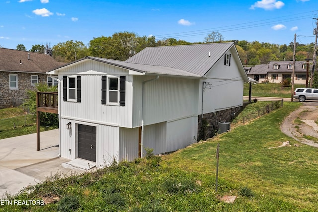 613 N St, Newport, TN 37821 - view of home's exterior featuring central air condition unit, driveway, metal roof, an attached garage, and a lawn
