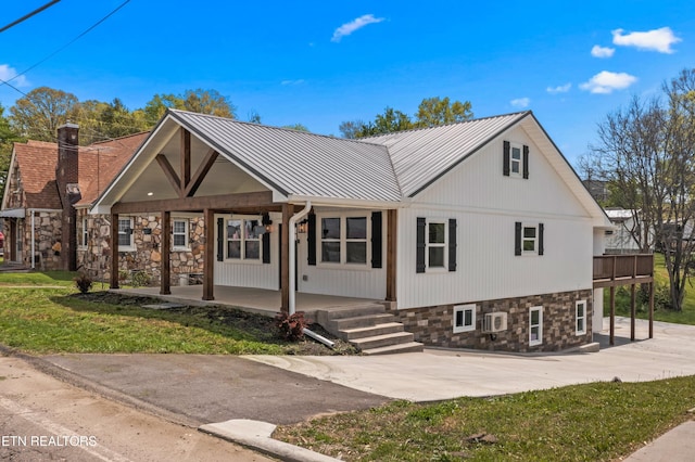 613 N St, Newport, TN 37821 - view of front facade with a wall mounted AC, stone siding, covered porch, and a front yard