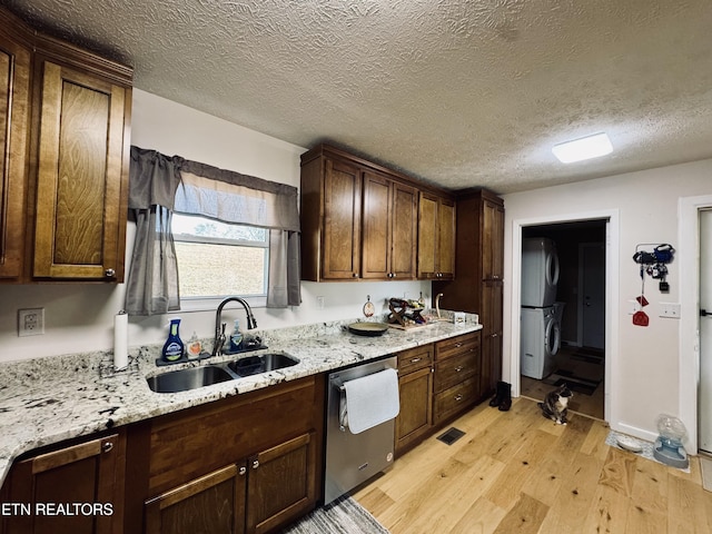 155 Oak Tree Ln, Sneedville, TN 37869 - kitchen with light wood finished floors, a sink, stacked washer / drying machine, dishwasher, and light stone countertops