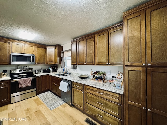 155 Oak Tree Ln, Sneedville, TN 37869 - kitchen featuring stainless steel appliances, visible vents, a sink, light wood-style flooring, and a textured ceiling