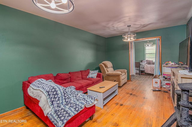 living area with wood-type flooring and a chandelier