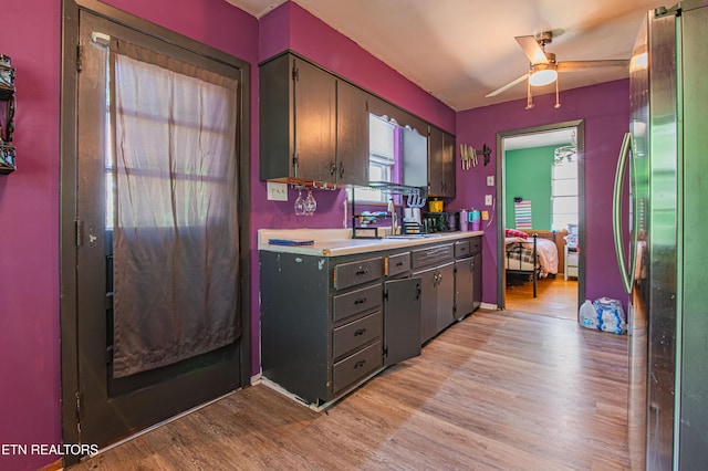 kitchen featuring light countertops, freestanding refrigerator, ceiling fan, light wood-style floors, and gray cabinetry