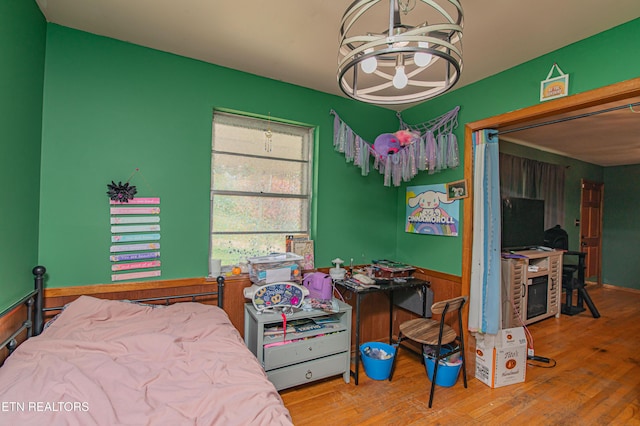 bedroom with a chandelier and wood finished floors