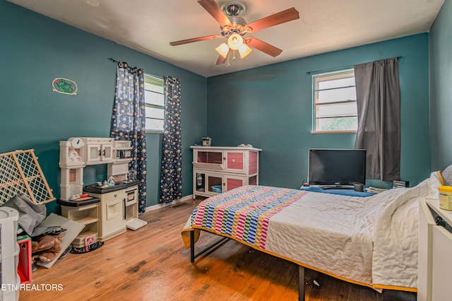 bedroom with wood finished floors, ceiling fan, and baseboards
