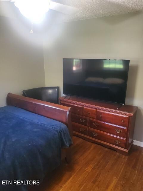 bedroom with dark wood-style floors and a ceiling fan