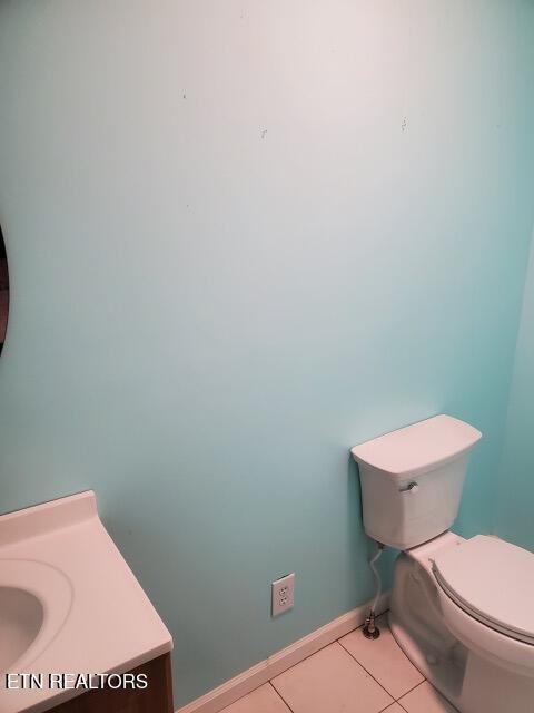 bathroom featuring toilet, baseboards, and tile patterned flooring