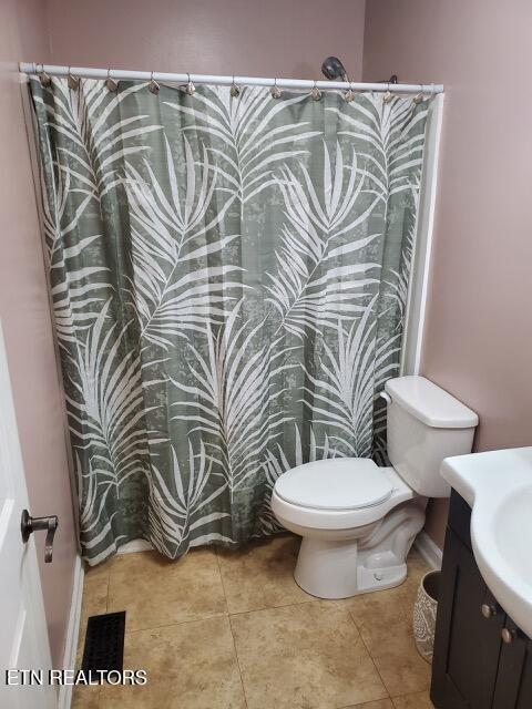 bathroom featuring vanity, a shower with curtain, tile patterned flooring, visible vents, and toilet