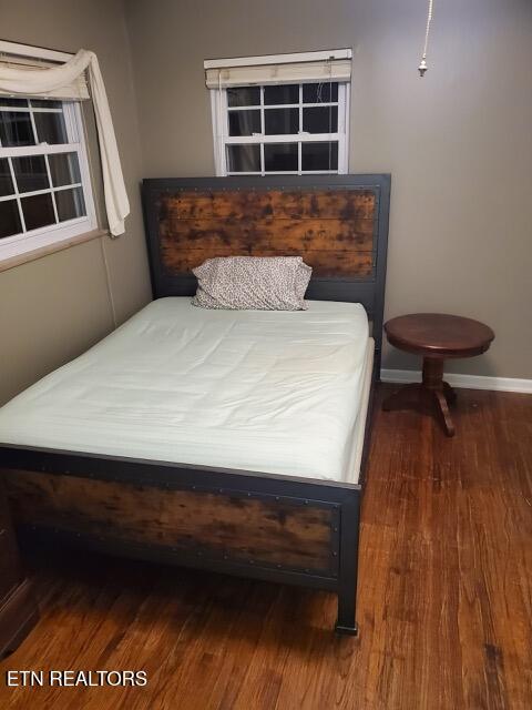 bedroom featuring baseboards and wood finished floors