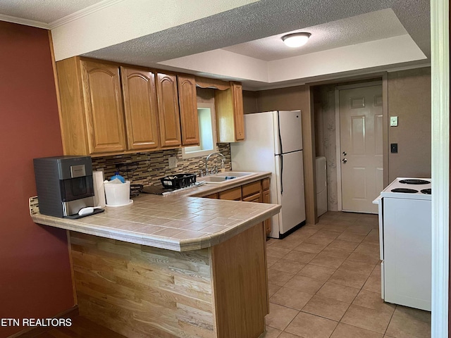 430 Buell Ln, Speedwell, TN 37870 - kitchen with light tile patterned floors, a sink, white appliances, decorative backsplash, and a peninsula